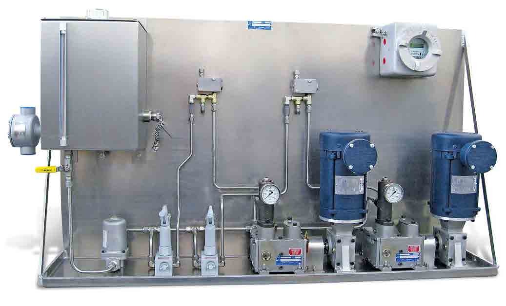 Industrial lubrication system featuring three electric motors, pumps, and pressure gauges mounted on a stainless steel panel, designed for efficient lubricant distribution in industrial applications.