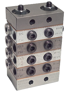 Industrial lubrication manifold featuring multiple ports and connectors, designed for efficient distribution of lubricants in machinery.