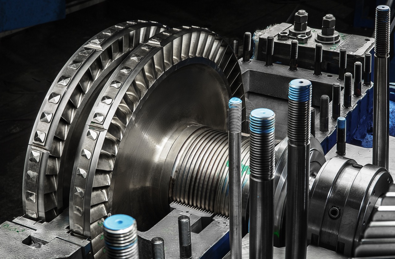 Close-up of precision-engineered machinery components, showcasing a large turbine assembly with intricate detailing and metallic textures, highlighting the complexity of industrial manufacturing processes.