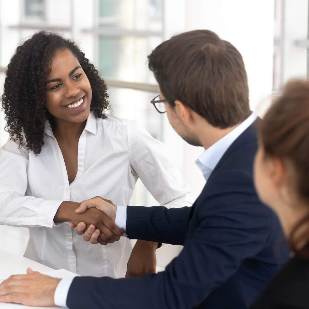 Business professionals shaking hands in a modern office setting, highlighting a successful meeting and collaboration.