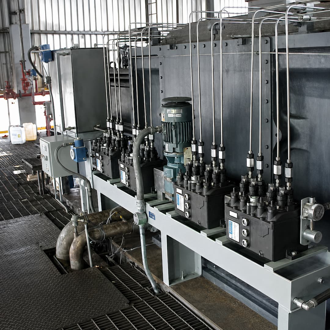 Industrial lubrication systems featuring multiple control units, valves, and a motor, designed for efficient fluid distribution in a manufacturing environment.