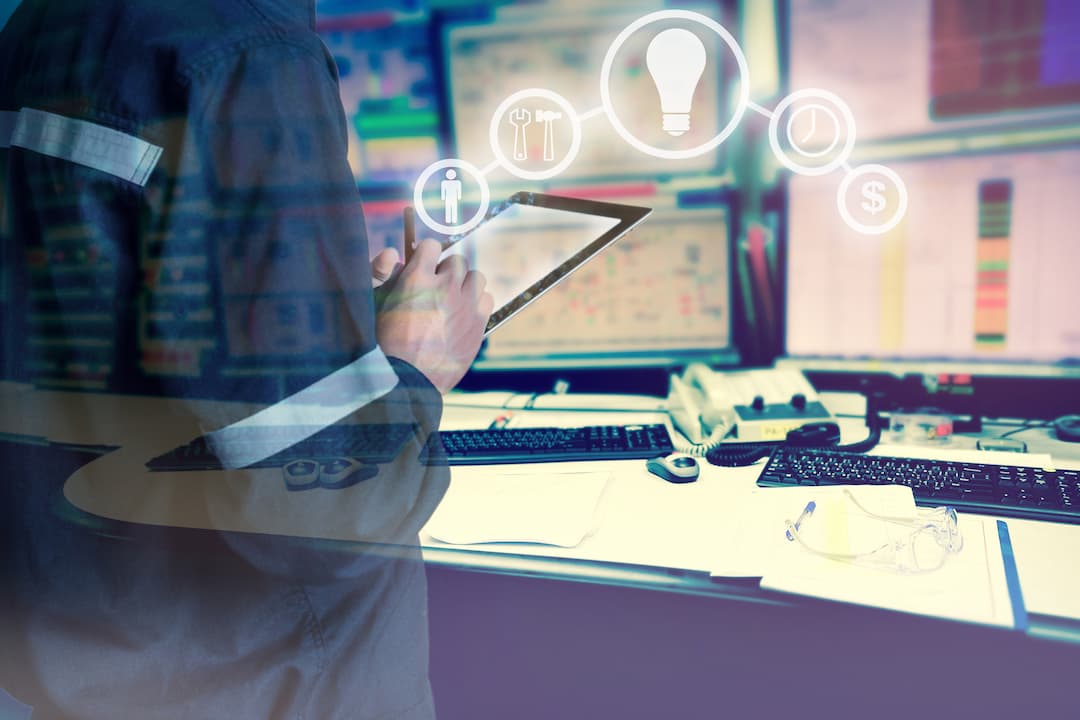 Technician using a tablet to manage maintenance tasks, surrounded by computer monitors displaying data and icons representing tools, information, and budgeting, emphasizing the digitization of maintenance processes.