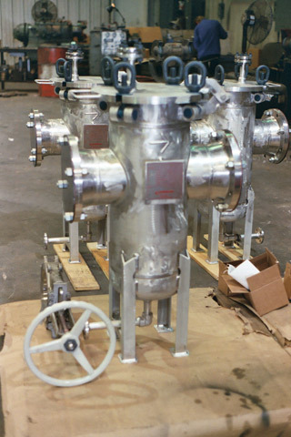 Stainless steel water basket strainers displayed in a workshop, showcasing their industrial design and functionality for efficient fluid filtration.