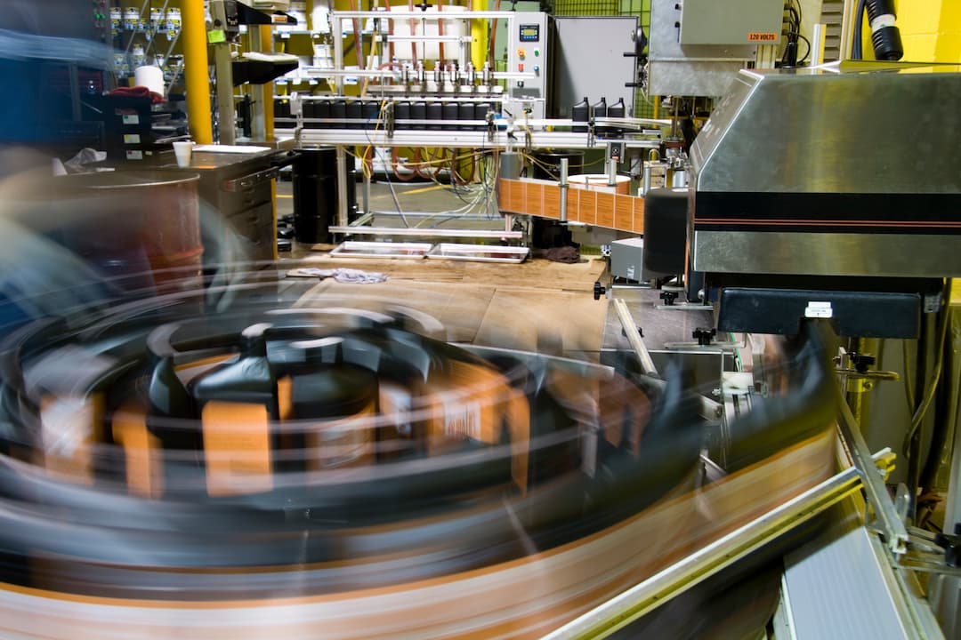 Image of a manufacturing facility showcasing machinery in motion, emphasizing an automated system designed to maximize throughput and efficiency in production processes.