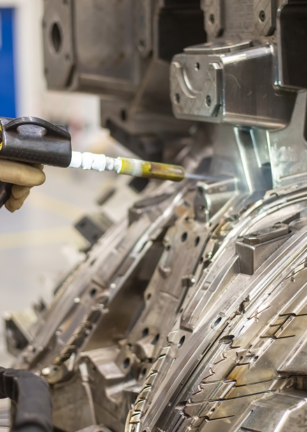 Close-up of a technician using a welding tool on intricate metal components in a manufacturing facility, showcasing precision engineering and advanced fabrication techniques.