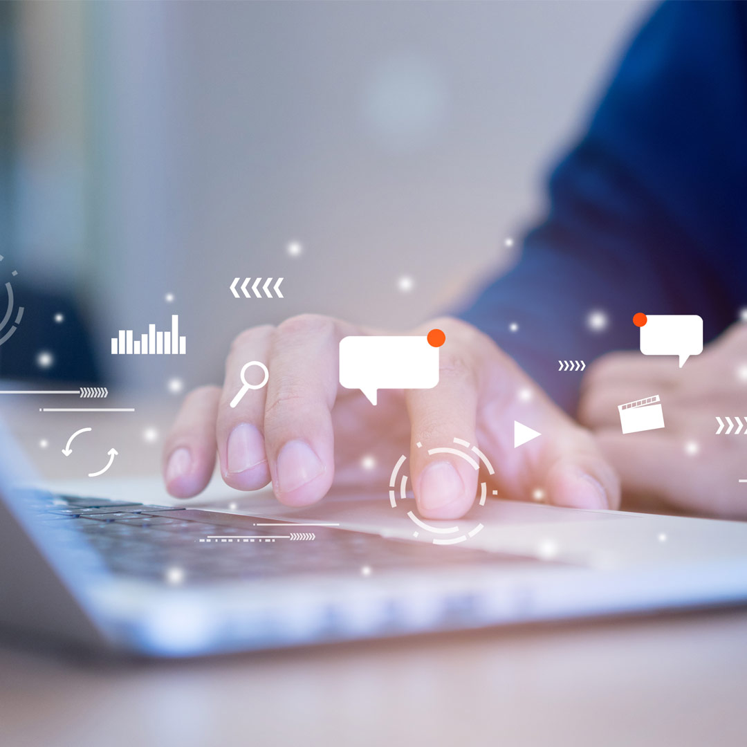 Person using a laptop with digital communication icons overlay, symbolizing online connectivity and engagement.