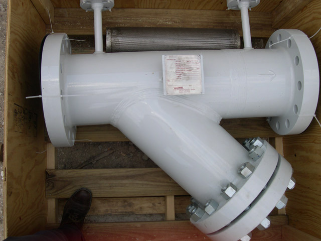 Y strainer with flanged connections and a mesh screen, positioned in a wooden crate for shipping. This industrial component is designed to filter out debris from liquids in piping systems, ensuring efficient operation.